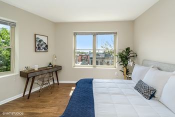 a bedroom with a large bed and two windows